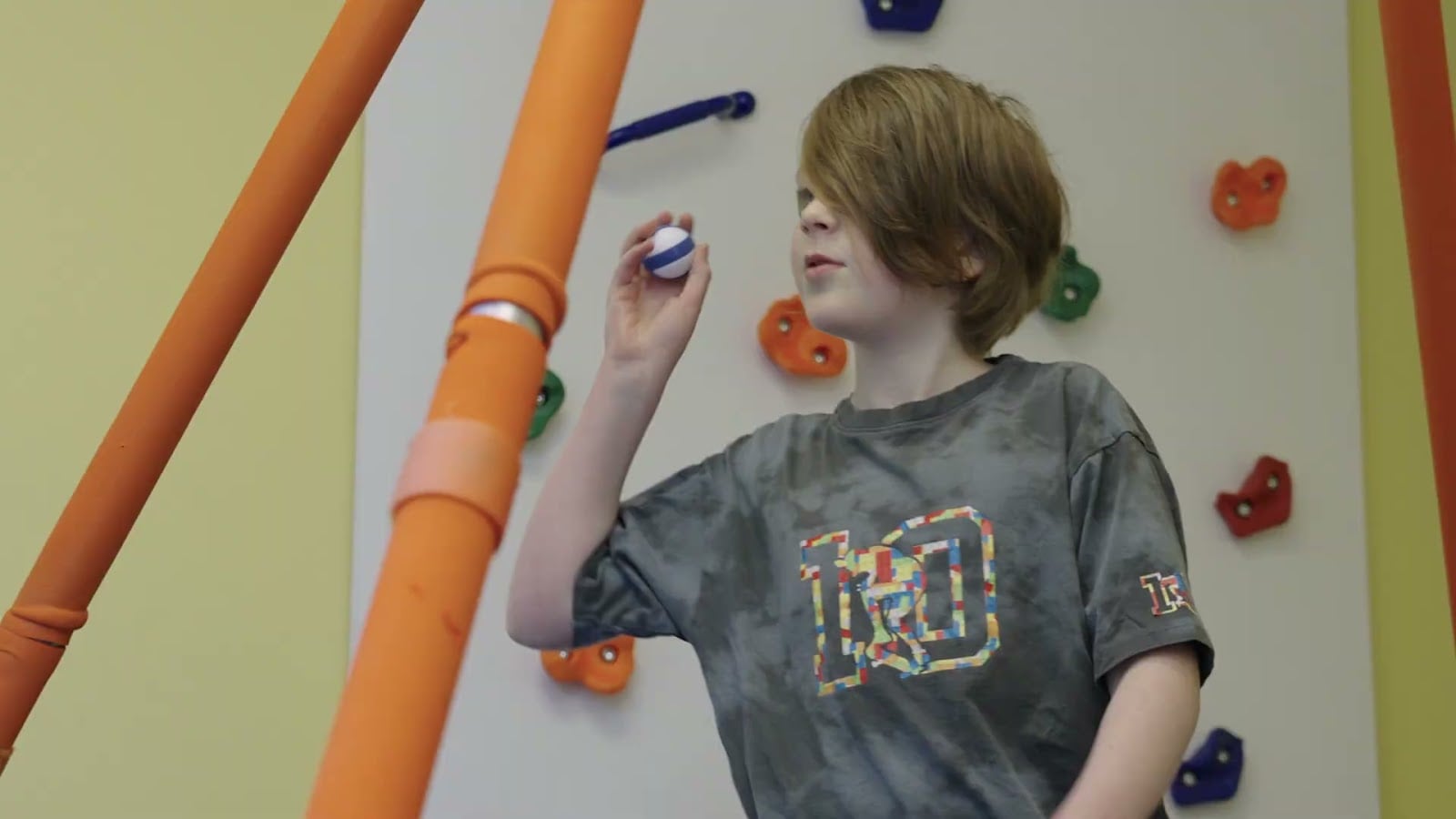Child on the climbing wall during a session at KidStart Pediatric Therapy in Burnaby BC